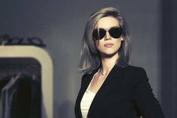 Young fashion blond woman in sunglasses in the mall interior