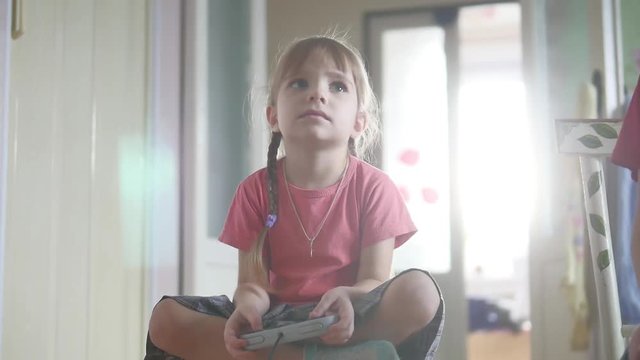 Young child girl playing video game Gamer girl with controller gamepad