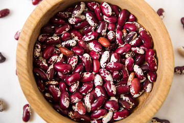 red kidney beans.wooden plate.white background.top close-up view