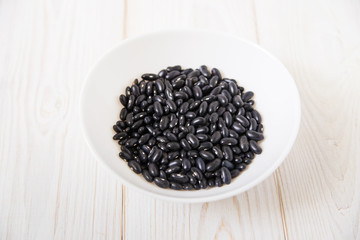 black kidney beans in the white plate.wooden background.