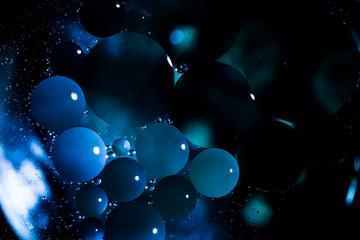 Abstract macro oil in water. I made this using a high powered falshlight and a vibrant blue food coloring. That way there are hard shadows and bright circles to create a a unique look.