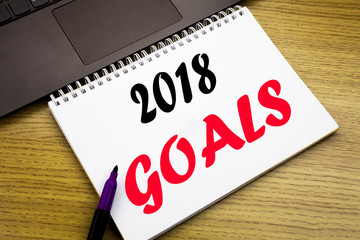 Hand writing text caption inspiration showing 2018 Goals. Business concept for financial planning, business strategy written on notebook book on the wooden background in the Office with laptop