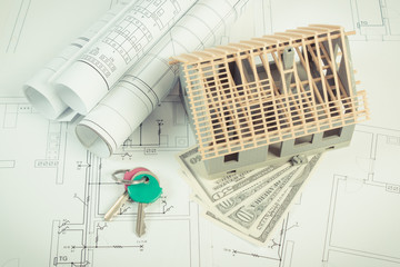 House under construction, currencies dollar and keys on electrical diagrams for project, building...