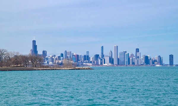 Chicago skyline on a cold winter day, as seen from the south side, with aqua blue Lake Michigan water in foreground.