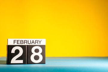 February 28th. Day 28 of february month, calendar on yellow background. Winter time, leap-year. Empty space for text