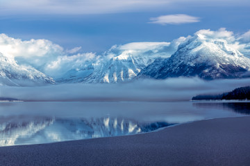 Fototapeta na wymiar Cloud shrouded mountains in winter above Lake McDonald, Glacier National Park, Montana