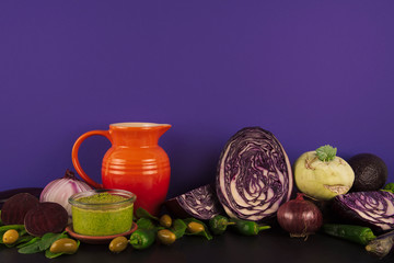 Assortment of raw organic purple and green vegetables.