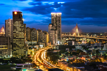 Obraz premium Top View of City Elevated Highway and Bangkok Cityscape with Bhumibol Bridge. Skyscraper with Car Traffic Light Trial at Night Time, Thailand