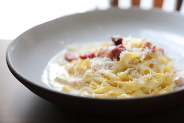 spaghetti carbonara white sauce with bacon on wood background in restaurant