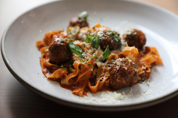 Spaghetti pasta with beef meatballs and tomato sauce on wood background . italian food