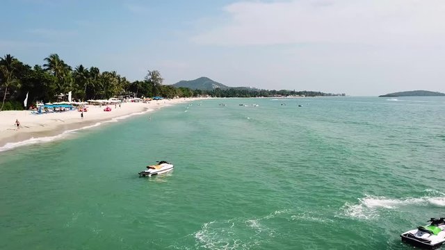 Top View of Paradise Beach. Beautiful tropical island with sand beach, palm trees. Aerial view of tropical beach on the island. Tropical landscape: beach with palm trees. Seascape: Ocean, sky, sea