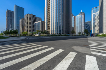 empty road with zebra crossing and skyscrapers in modern city.