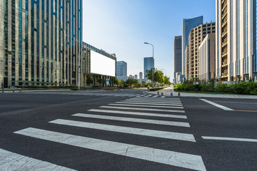 empty road with zebra crossing and skyscrapers in modern city. © hallojulie