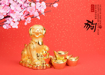 Chinese new year decoration:golden dog statue and gold ingots,translation of calligraphy: 2018 is year of the dog,red stamp: good Fortune for year