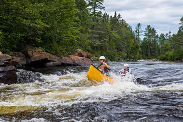 Group of people paddling the whitewater of the Noire River in Quebec, Canada.