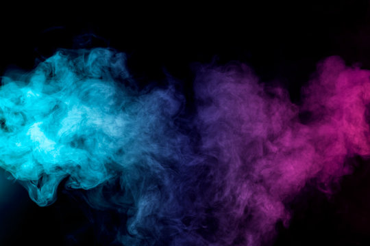 Dense multicolored smoke of   red, purple and pink colors on a black isolated background. Background of smoke vape