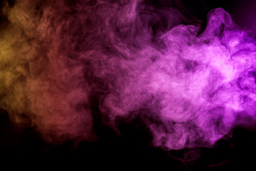 Thick colorful smoke of , red, orange pink on a black isolated background. Background from the...