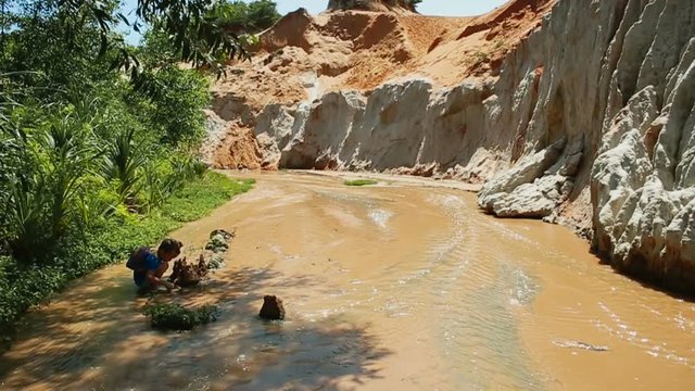 Kid traveler walking at Fairy Stream (Suoi Tien), the travel place in Muine, Vietnam
