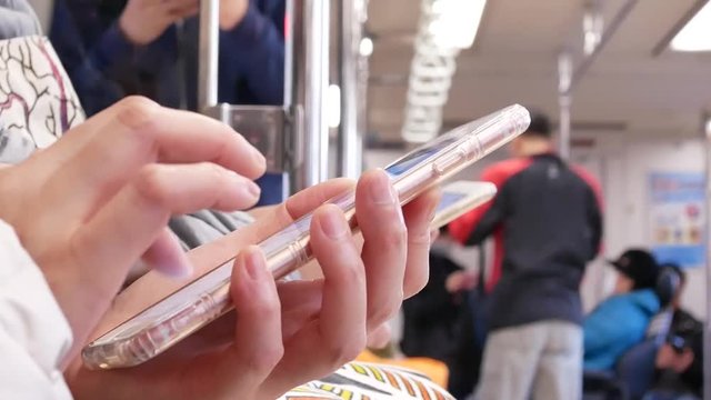 Motion of commuter taking MRT and playing phone in Taipei Taiwan with 4k resolution.