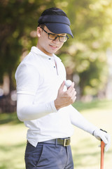Fototapeta na wymiar Asian men playing golf. men showing golf ball in hand standing on field
