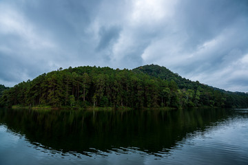 Fototapeta na wymiar Forest Mountain behind the river with cloudy sky in the morning, Traveling in Thailand (Pang Ung)