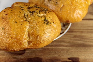 Fresh bread ciabatta on a plate on wooden table