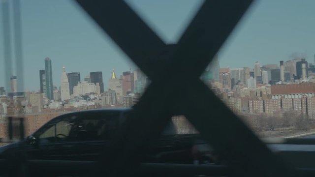 shot from the JMZ train riding the Williamsburg bridge overlooking at Manhattan and the Empire State building with traffic in the foreground