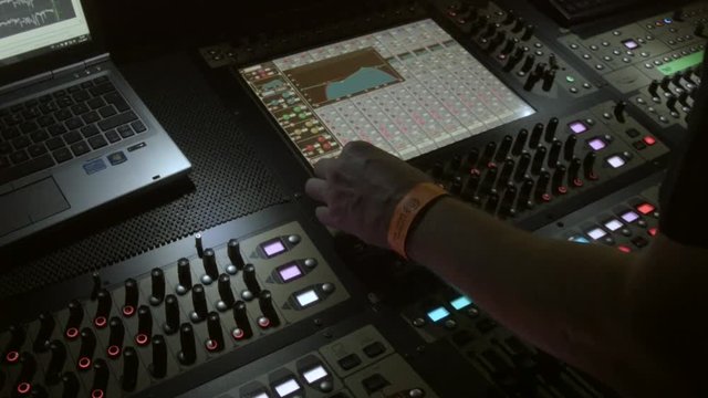 Sound enginner working on his console during live gig