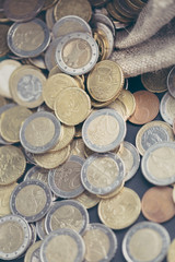 Euro coins scattered from the bag. The concept of saving money. Shallow depth of field.