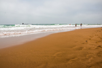 Fototapeta na wymiar Coast, waves and beach with yellow sand and pebbles