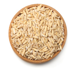 oat grains in wooden bowl isolated on white background. top view