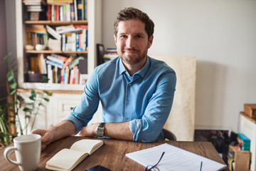 Smiling man working at his living room table at home