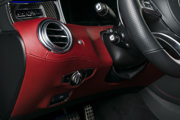 Obraz na płótnie Canvas AC Ventilation Deck in Luxury modern Car Interior. Modern car interior details with red and black leatherwith red stitchin. Carbon panel. Perforated leather steering wheel