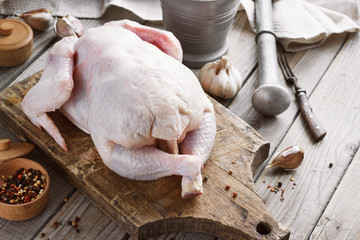 chicken carcass on a wooden background with spices, cooking in the kitchen, rustic style