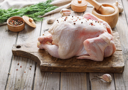 chicken carcass on a wooden background with spices, cooking in the kitchen, rustic style