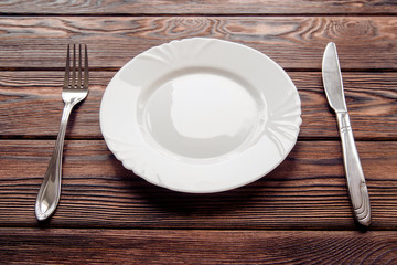Cutlery lying on a brown wooden background 