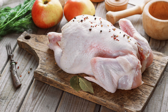 chicken carcass on a wooden background with spices and apples, cooking in the kitchen, rustic style