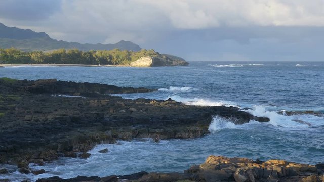 Slow motion (59.94 fps rendered at 29.97), locked down view of Shipwreck Beach in Keoniloa Bay, Poipu, Kauai, Hawaii near sunset.