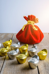 Chinese New Year Red fabric bag, ang pow with Chinese money of luck and Shoe-shaped gold ingot