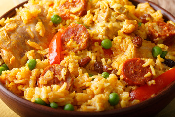 Arroz Valenciana with rabbit, chorizo, vegetables and spices macro in a bowl. horizontal