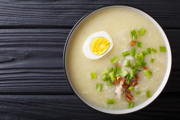 Arroz Caldo soup with rice, chicken and egg close-up. horizontal top view