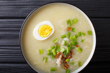 Thick rice soup with chicken, garlic, onion and egg close-up. horizontal top view from above