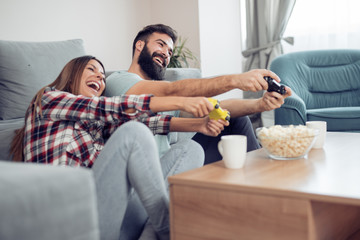 Happy couple having fun with new game consoles trends technology