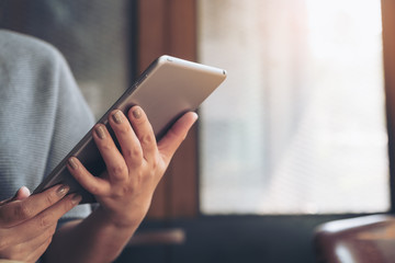 A woman's hands holding and using tablet pc in cafe