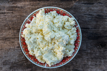 Homemade cottage cheese on old wooden table