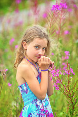 adorable girl enjoys life and gathers wildflowers