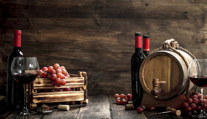 Wine background. A barrel with red wine and freshly grapes.
