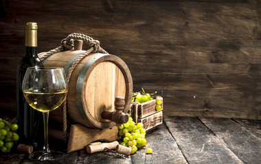 Wine background. A barrel of white wine with branches of green grapes. - obrazy, fototapety, plakaty