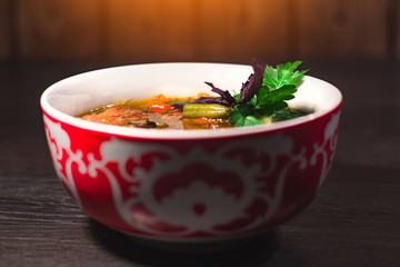 A plate of hot oriental soup with meat and noodles