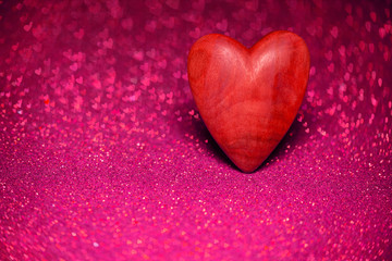 Wooden red heart on a red blurred background